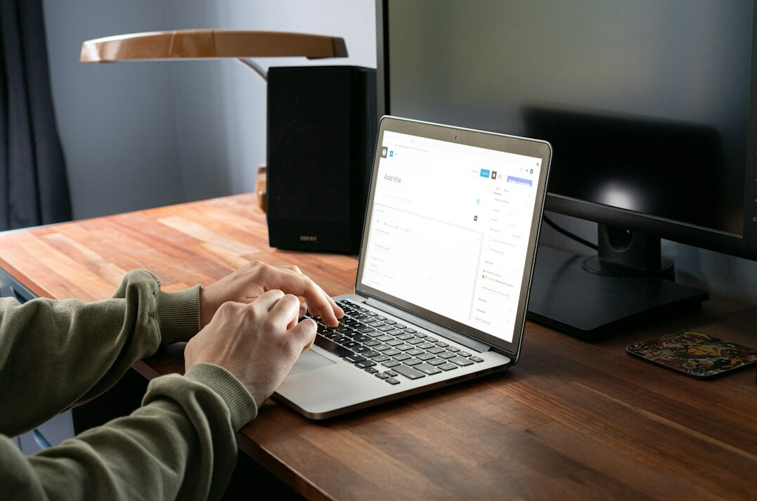 person coding on laptop at desk