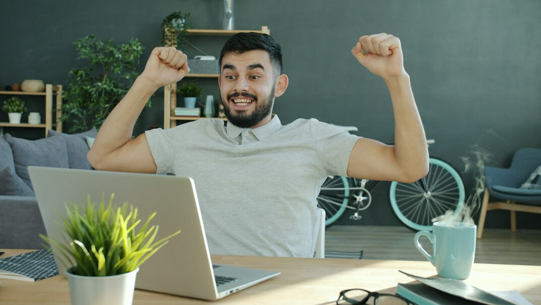 person celebrating success at computer